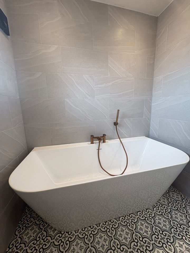 Freestanding bath with copper tap and patterned floor